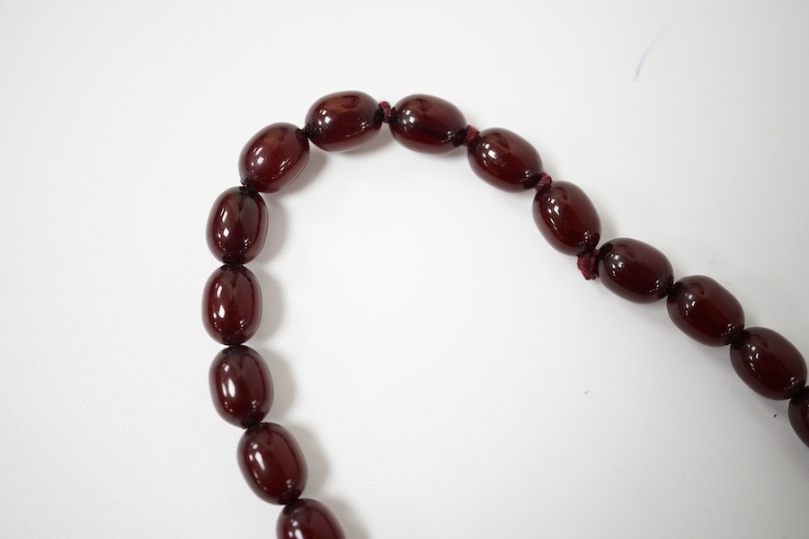 A single strand graduated simulated cherry amber bead necklace, 68cm, gross weight 44 grams. Condition - fair to good